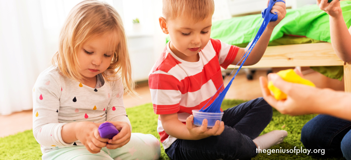 preschool aged boy and girl playing on the floor with colored slime