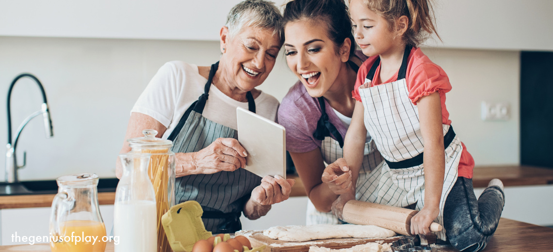 multi generational family of a grandmother, mother and young daughter looking at a recipe in the kitchen to cook a new meal 