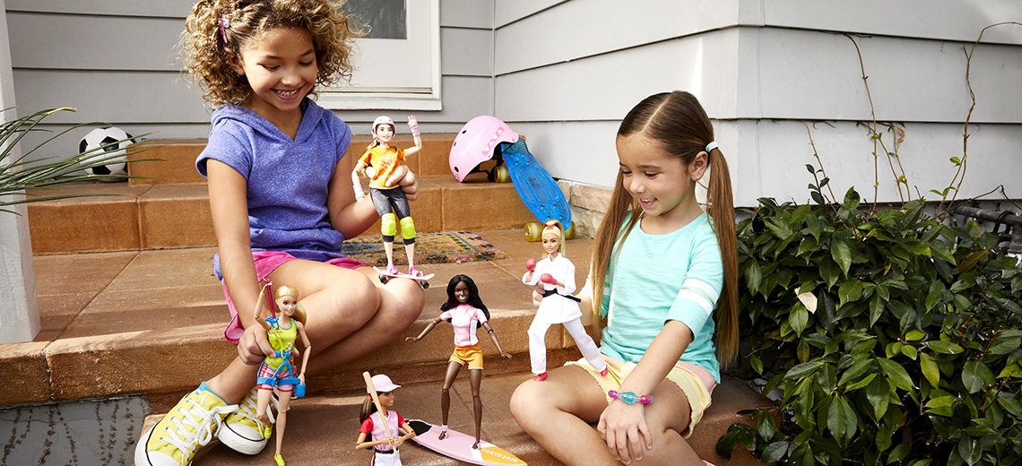 young girls playing with barbie