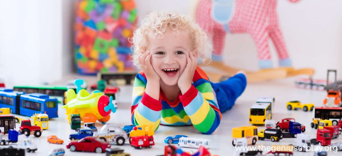 Boy on floor surrounded by lots of toy cars