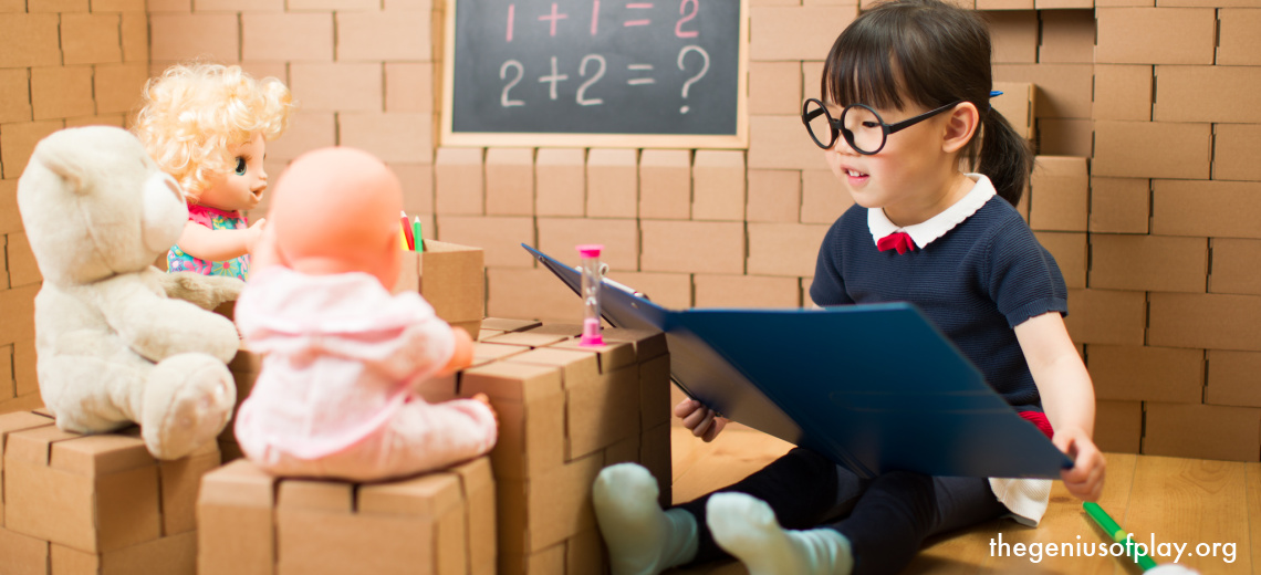 Asian toddler girl pretend playing to be a teacher with her dolls and stuffed animals at home