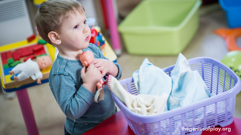 young boy toddler showing empathy taking care of a toy doll