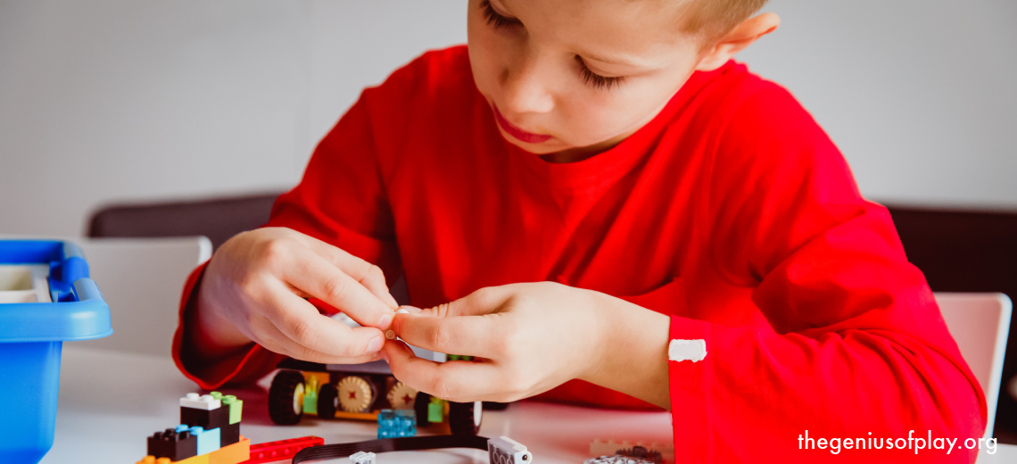 elementary school age boy playing with toy game parts