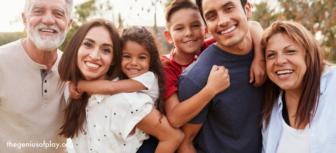 multi generational Hispanic family standing close together in the park smiling