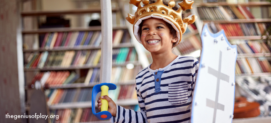 elementary school-aged African American boy playing pretend dressed as a knight with a sword and shield