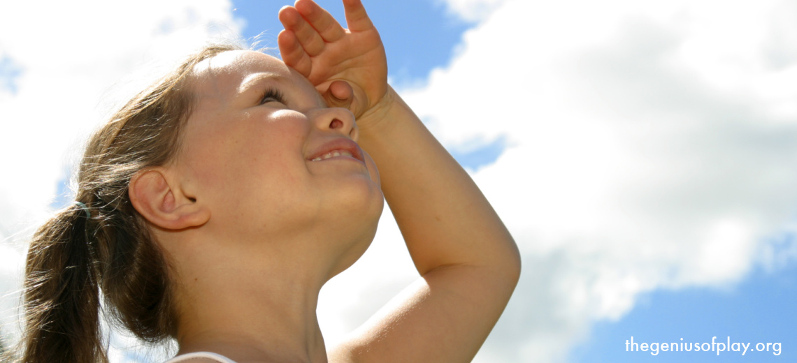 young girl looking up at the clouds in the sky