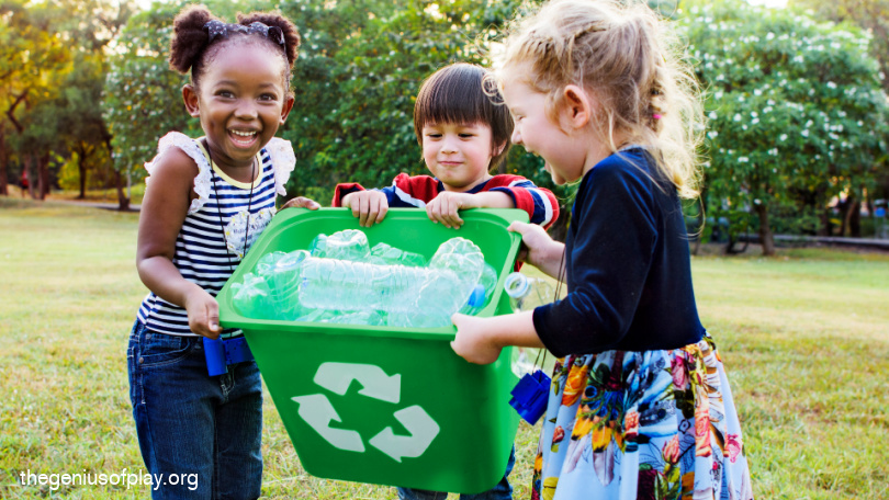 three elementary school age kids carrying a recycling bucket