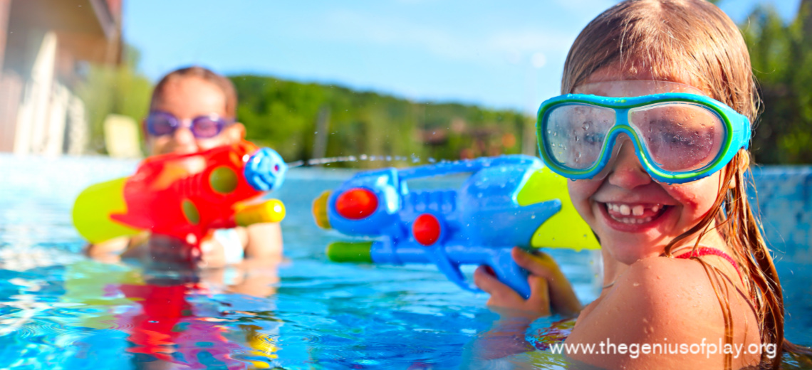 two elementary school age girls playing with water blasters in a swimming pool