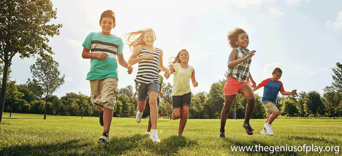 Diverse group of young kids running with grass field in nature for fun, playful day or sunshine at park.